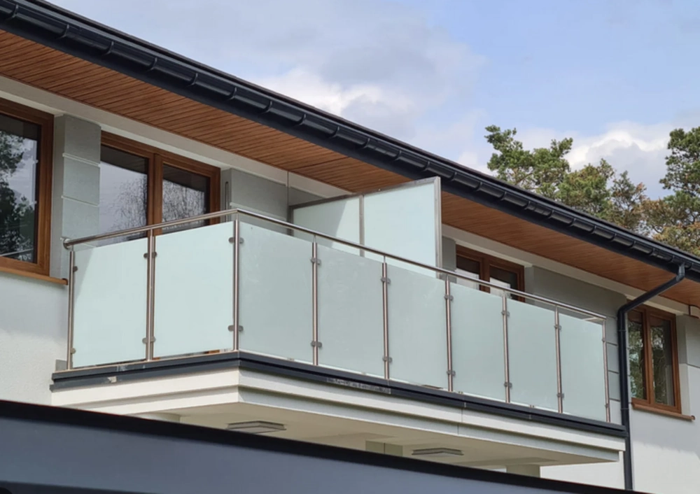 Glasgeländer mit mattierten Scheiben und Edelstahlpfosten an modernem Wohnhausbalkon