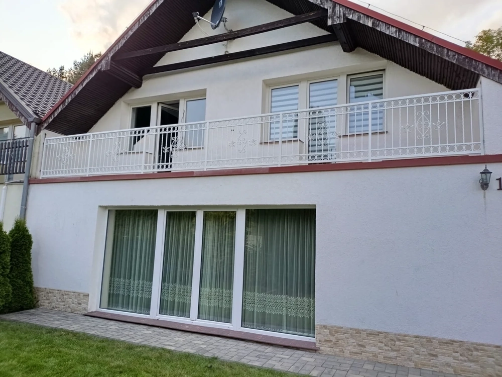 Weißes Geländer am Balkon eines zweistöckigen Hauses